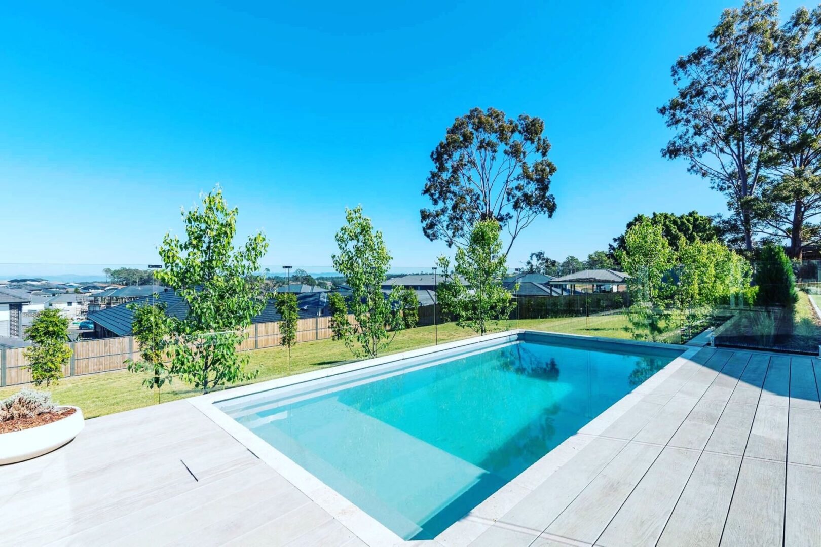 A pool with trees and bushes in the background