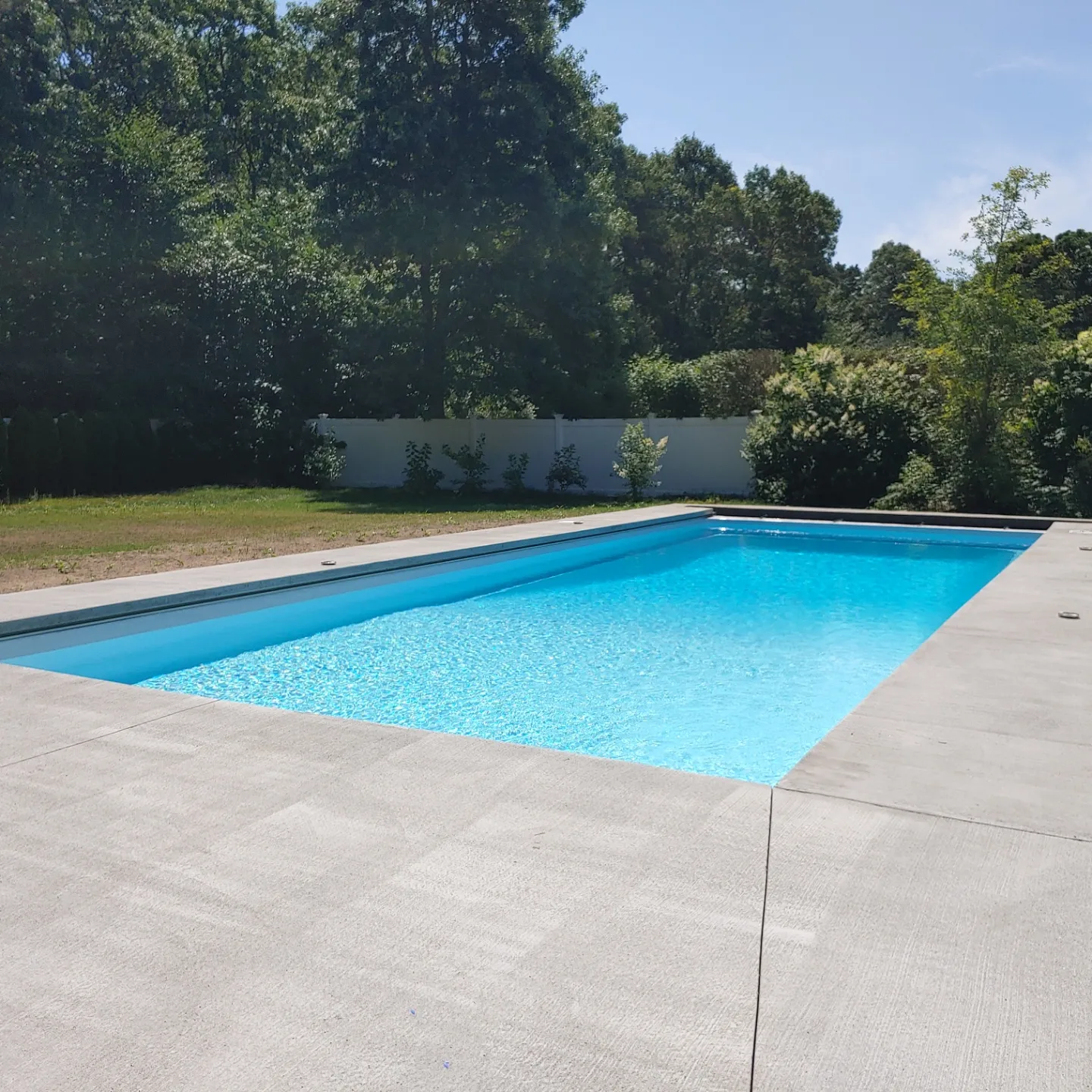 A pool with a large concrete slab in the middle of it.